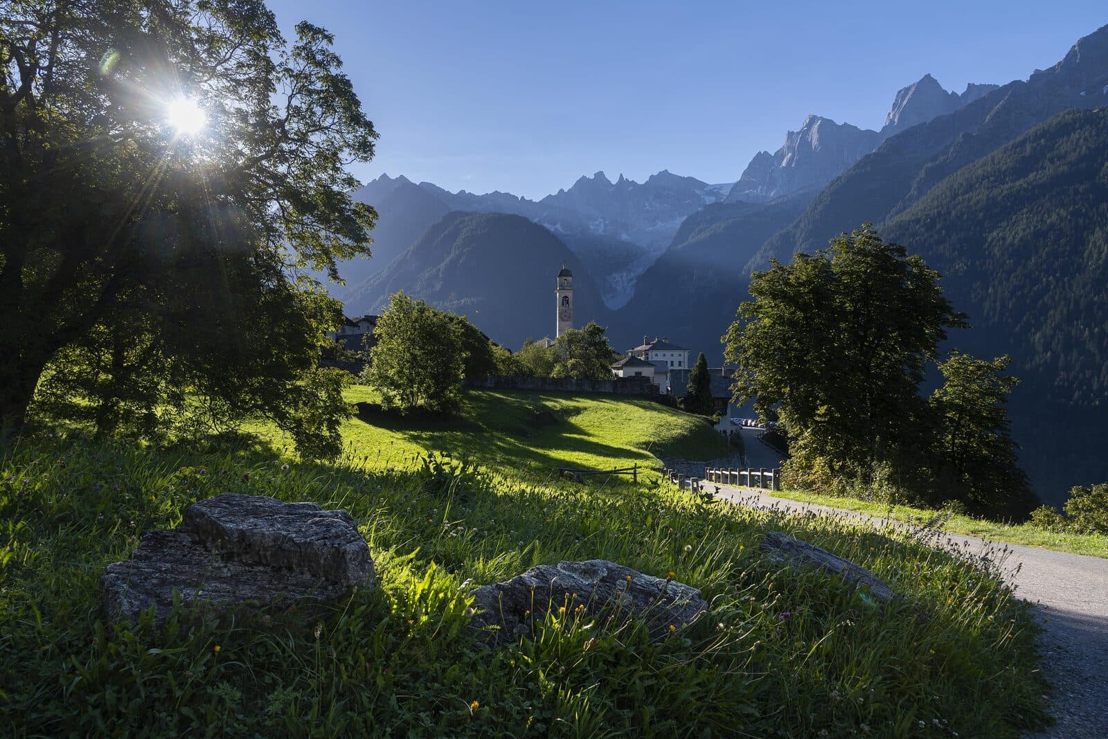 A high alpine valley with a stone village and snow peaks