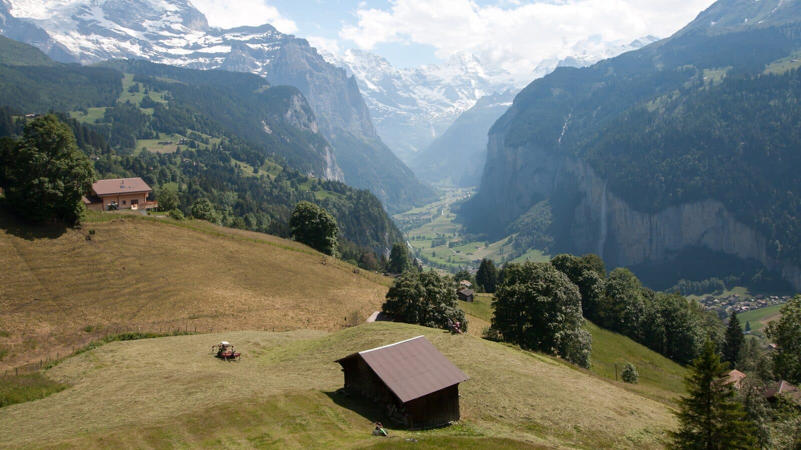 The Lauterbrunnen valley seen from Wengen, with meadows, barns and steep rock walls